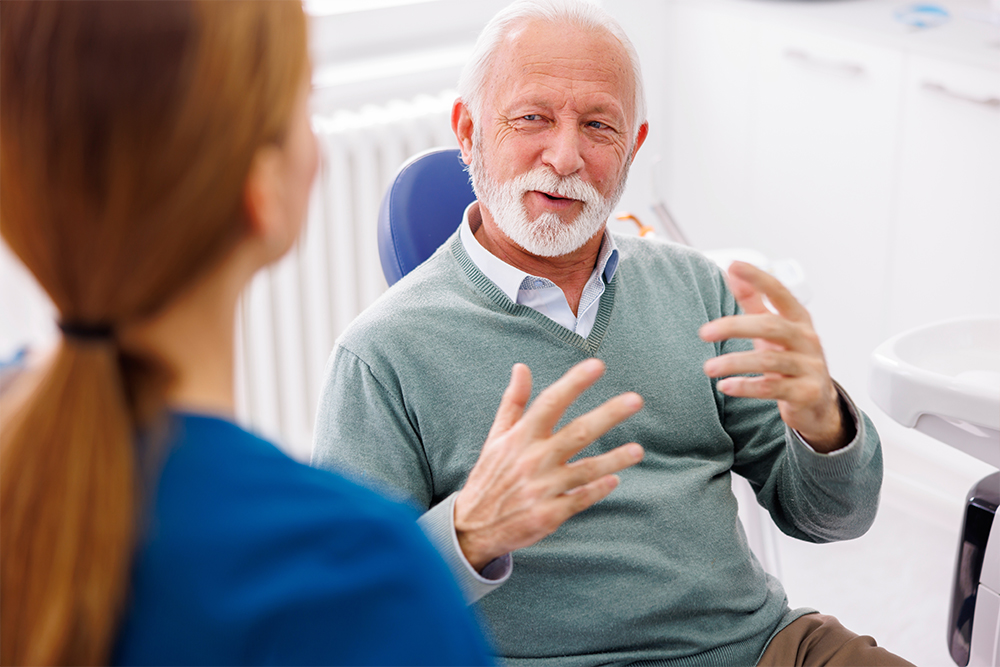 Patient receiving dental implant consultation at Greenwood Park Dentistry in Kingston with dentist explaining tooth restoration options